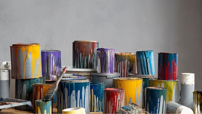 Old Paint Cans, copy space, background. Cans of colored paint. Oil-based enamel, lacquer, shellac and varnish leftovers. Household Hazardous Waste