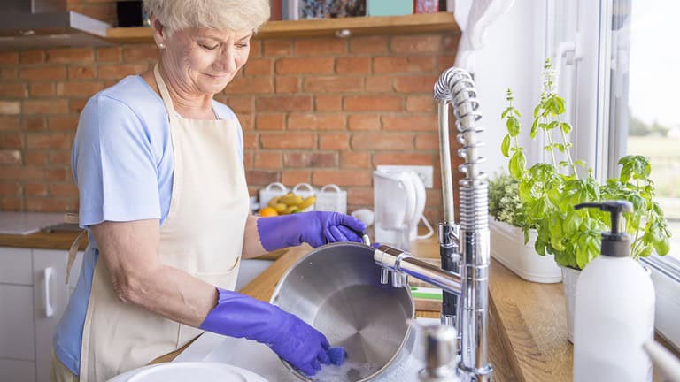 woman grandmother washing dishes cleaning up