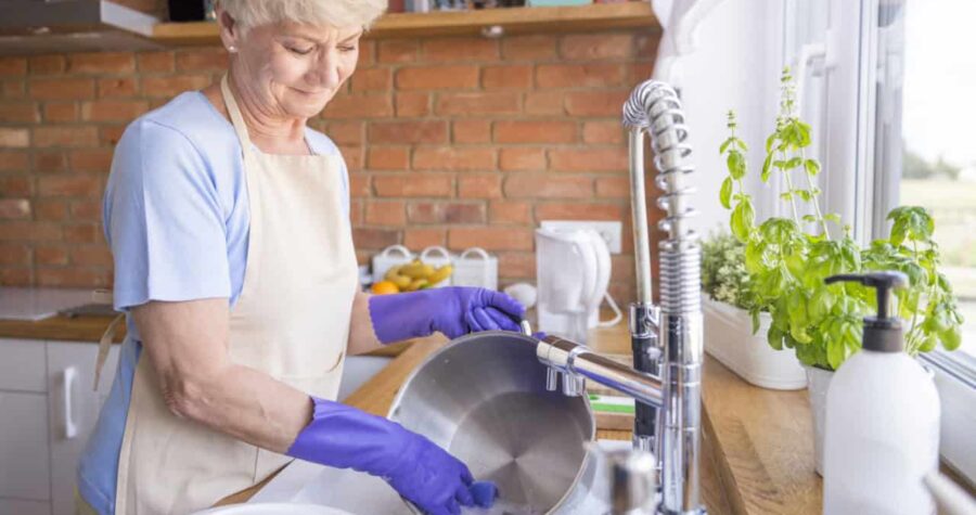 woman grandmother washing dishes cleaning up