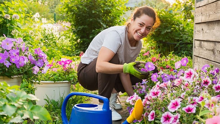 Gardening and agriculture concept. Young woman farm worker gardening flowers in garden. Gardener planting flowers for bouquet