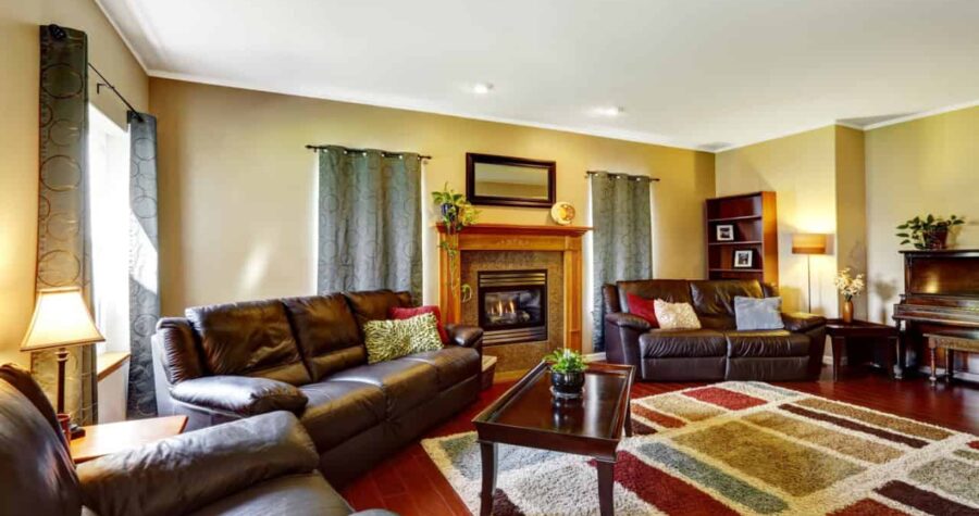 Living room interior with leather couches and colorful soft rug