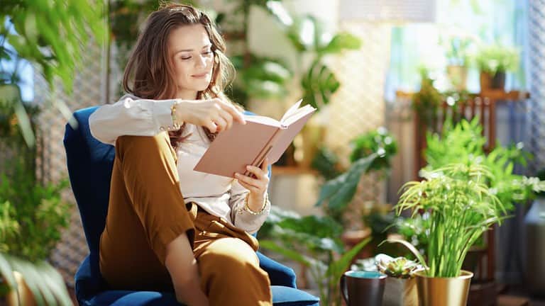 woman reading book, plants, gardening