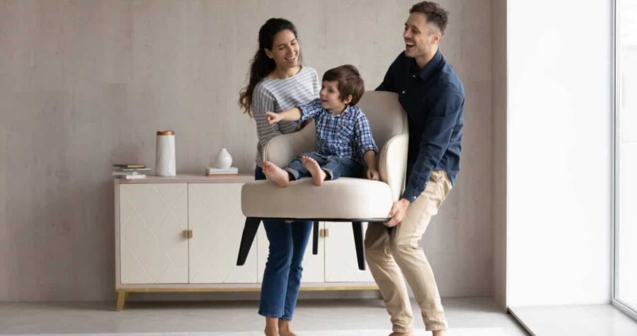A happy renting couple with a child in a chair