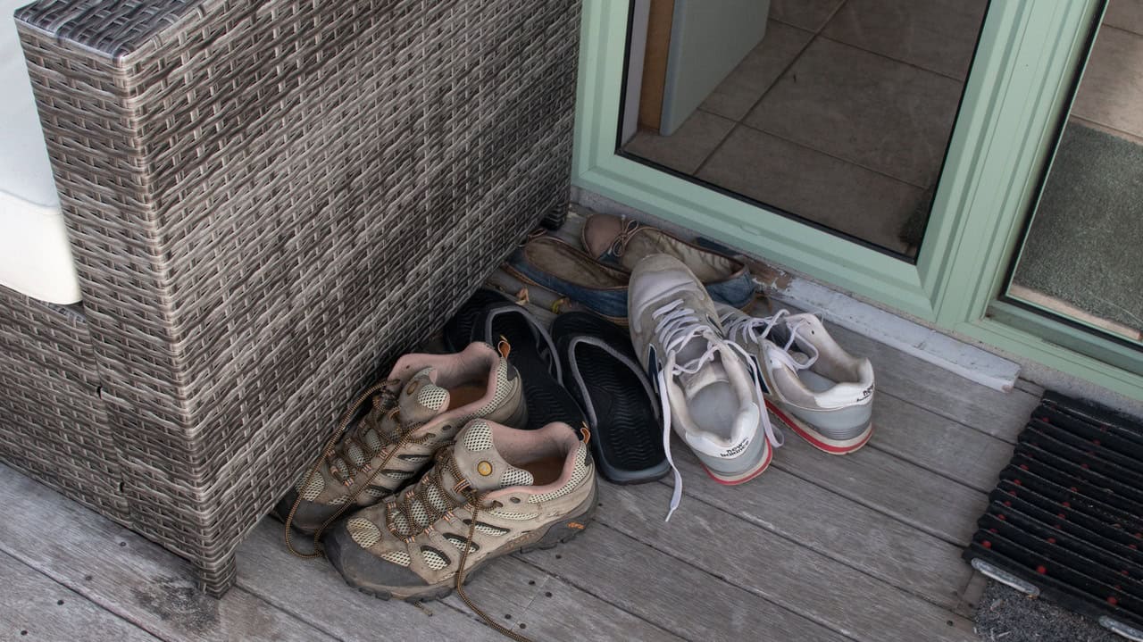 pile of shoes left by the doorway , leave shoes outside