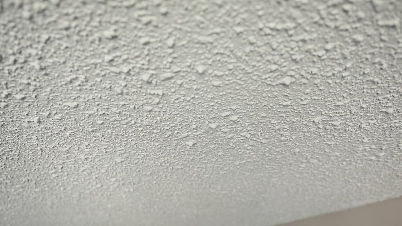 Textured white popcorn ceiling showing bumpy, irregular surface pattern with small raised particles creating dimensional effect
