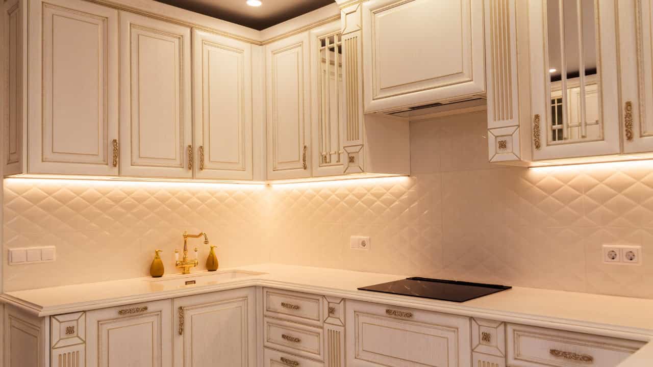 Modern kitchen, white cabinets with detailed design, under-cabinet lighting, minimalist aesthetic, well-organized, stylish and functional kitchen design