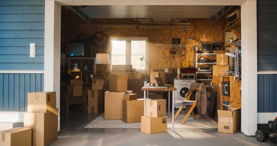 Dusty basement or storage room with cardboard boxes, wooden shelves, concrete floor, small window with natural light
