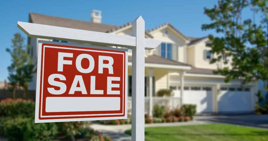 Red and white "For Sale" sign in front of a modern two-story suburban house