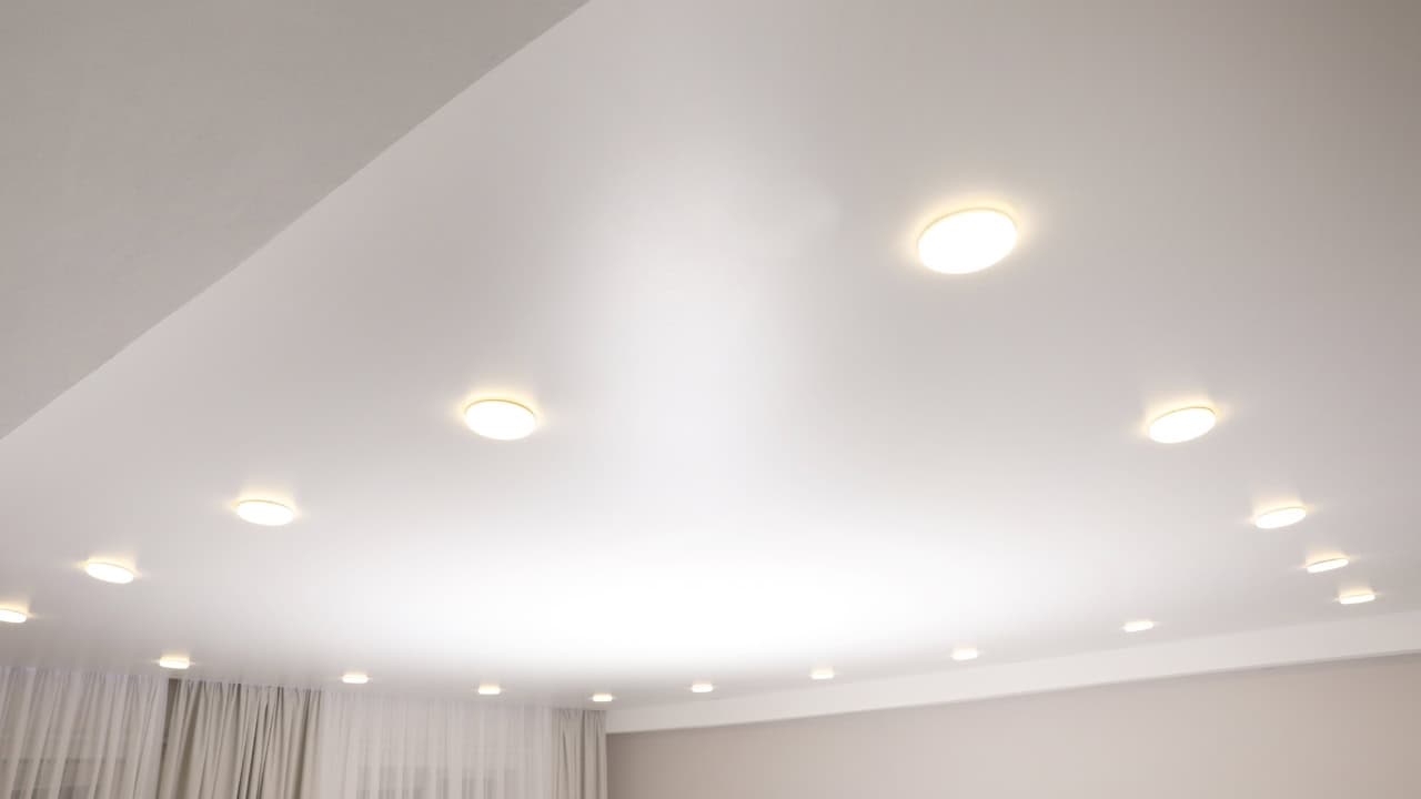 Ceiling with recessed lighting, evenly spaced LED lights, soft white glow, modern interior design, bright and minimalistic room, smooth white ceiling, well-lit space