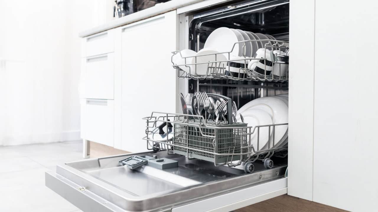 Open dishwasher, clean dishes, neatly arranged plates, cups, and utensils, modern kitchen, stainless steel interior