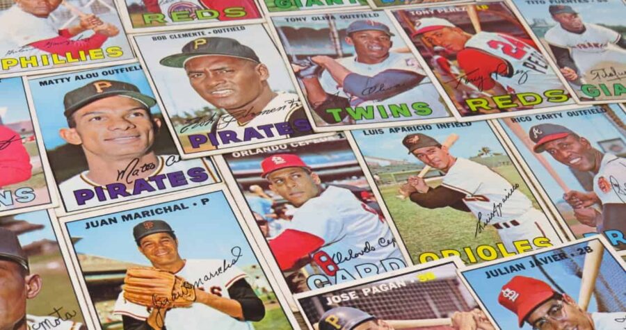 A collection of vintage baseball cards from various teams, featuring players like Roberto Clemente, Juan Marichal, and Matty Alou, with colorful team names and player signatures on each card