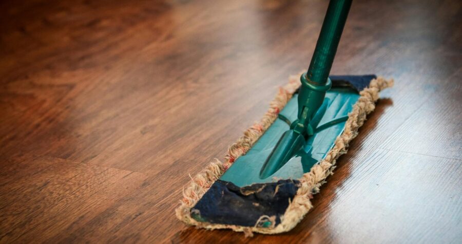 A detailed view of a mop cleaning a wooden floor, showing texture and pattern.