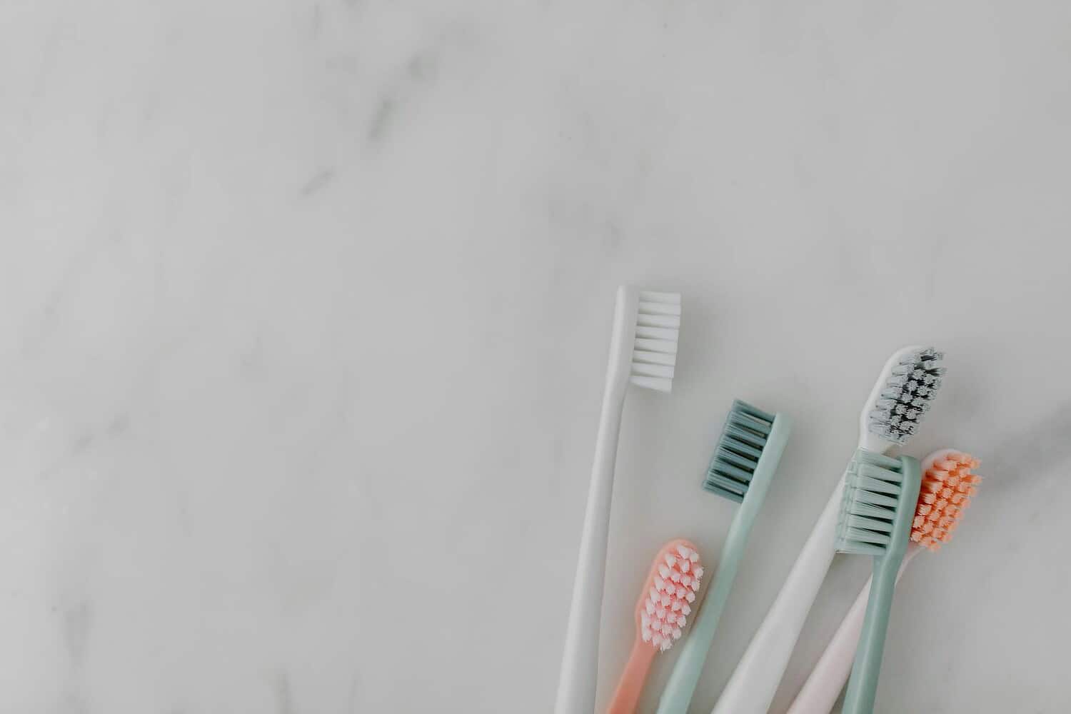 Aesthetic arrangement of colorful toothbrushes on a marble background.