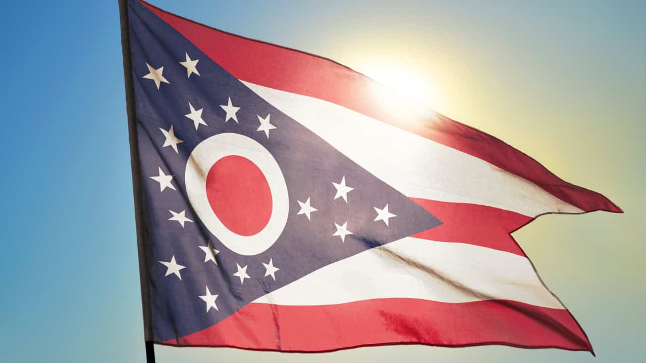 Ohio state flag with countryside in background