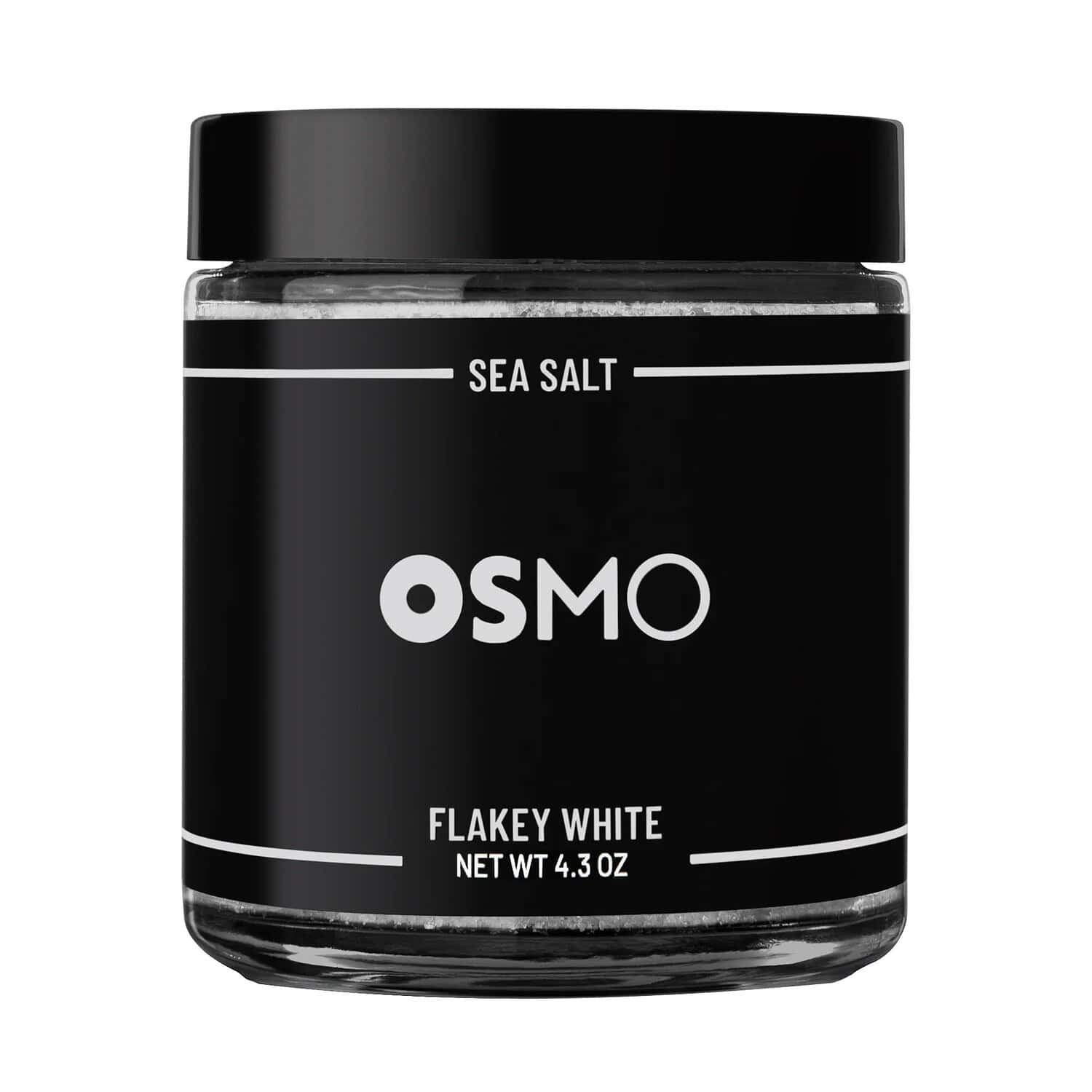 A jar of Osmo Flakey White Sea Salt is displayed with a sleek black label, the jar is labeled with the product name, net weight of 4.3 oz, and is designed for gourmet cooking and seasoning, the black packaging contrasts with the white salt inside, highlighting the premium quality of the product
