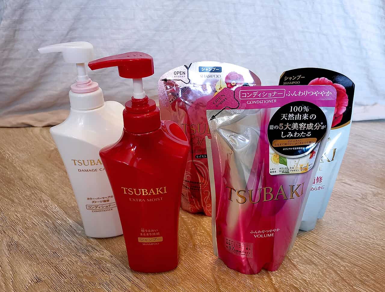 Bottles and refill packs of Tsubaki hair care products, including shampoo and conditioner, various types such as Damage Care, Extra Moist, and Volume