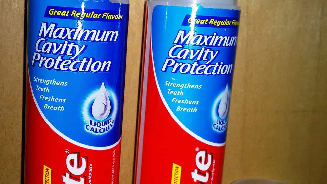 Two tubes of Colgate toothpaste with Maximum Cavity Protection formula, featuring blue and red packaging, displaying 'Great Regular Flavour' and 'Liquid Calcium' on the labels