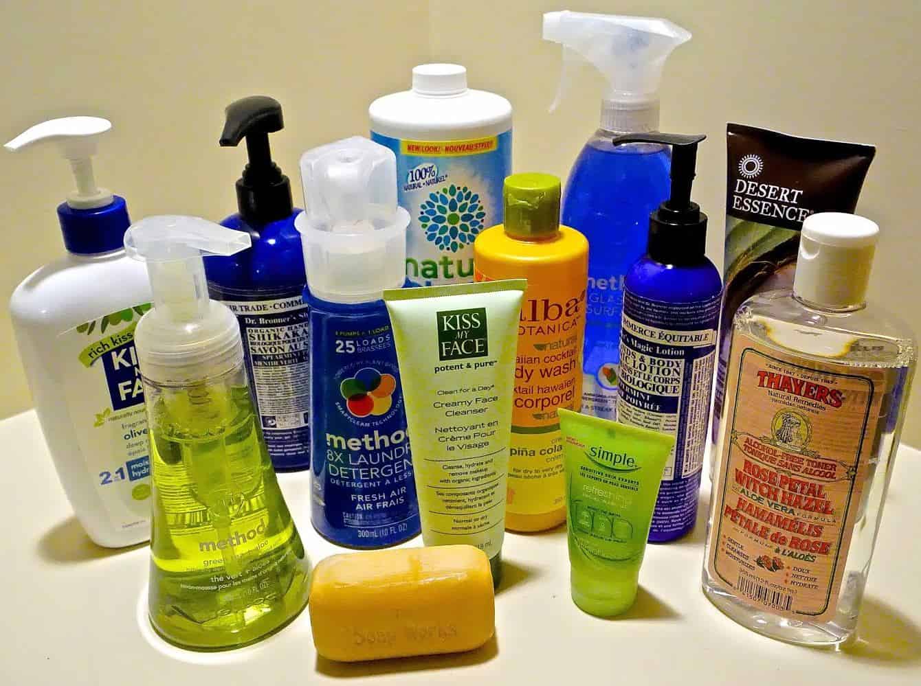The image shows various personal care products, including bottles of soap, face wash, body wash, detergent, and lotion, arranged on a flat surface