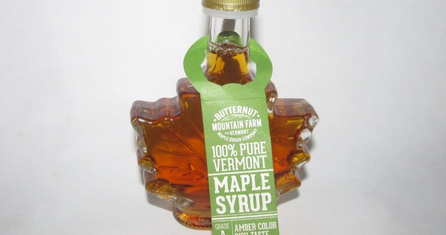 Maple leaf-shaped glass bottle of Butternut Mountain Farm 100% Pure Vermont Maple Syrup, amber color, Grade A, 1.7 fl. oz, green label, gold cap, white background