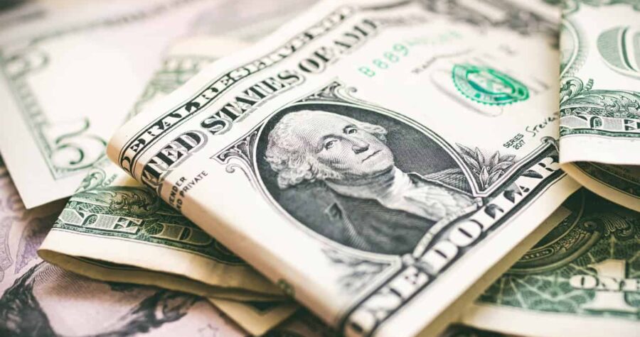 U.S. dollar bills, with a prominent one-dollar bill featuring George Washington's portrait, stacked together, symbolizing currency or money