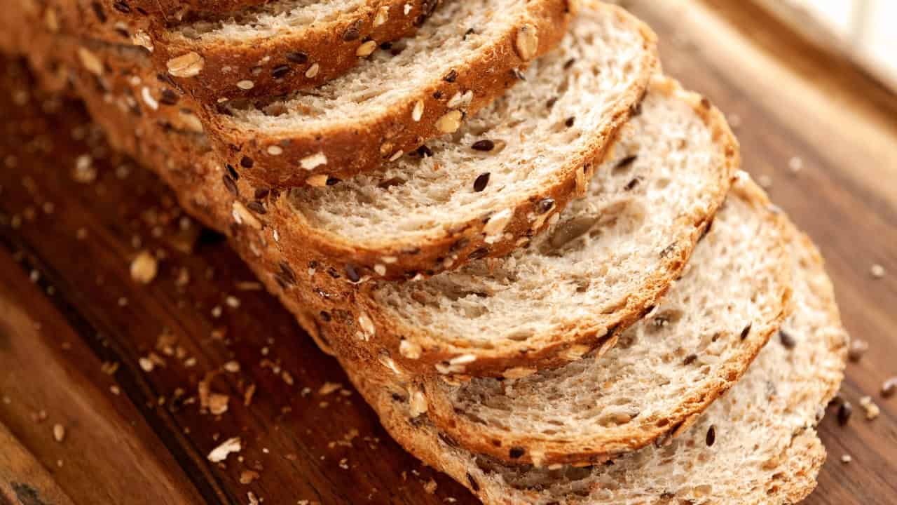 Sliced whole grain bread, slices of multigrain bread stacked, healthy bread with seeds, fresh baked whole wheat bread, close-up of whole grain bread slices