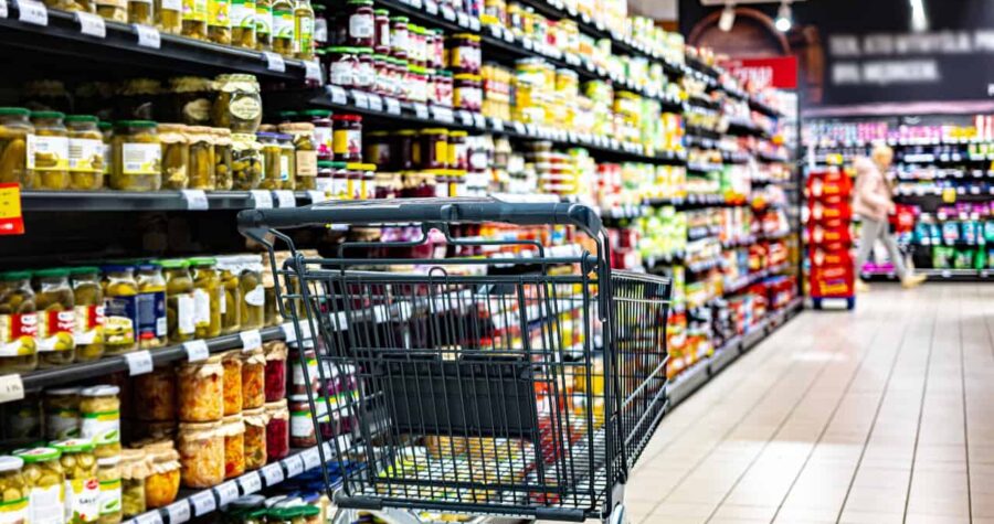 Grocery shopping cart, shelves filled with jars and canned goods, supermarket aisle, empty shopping cart in grocery store, looking for food items in store, food shopping