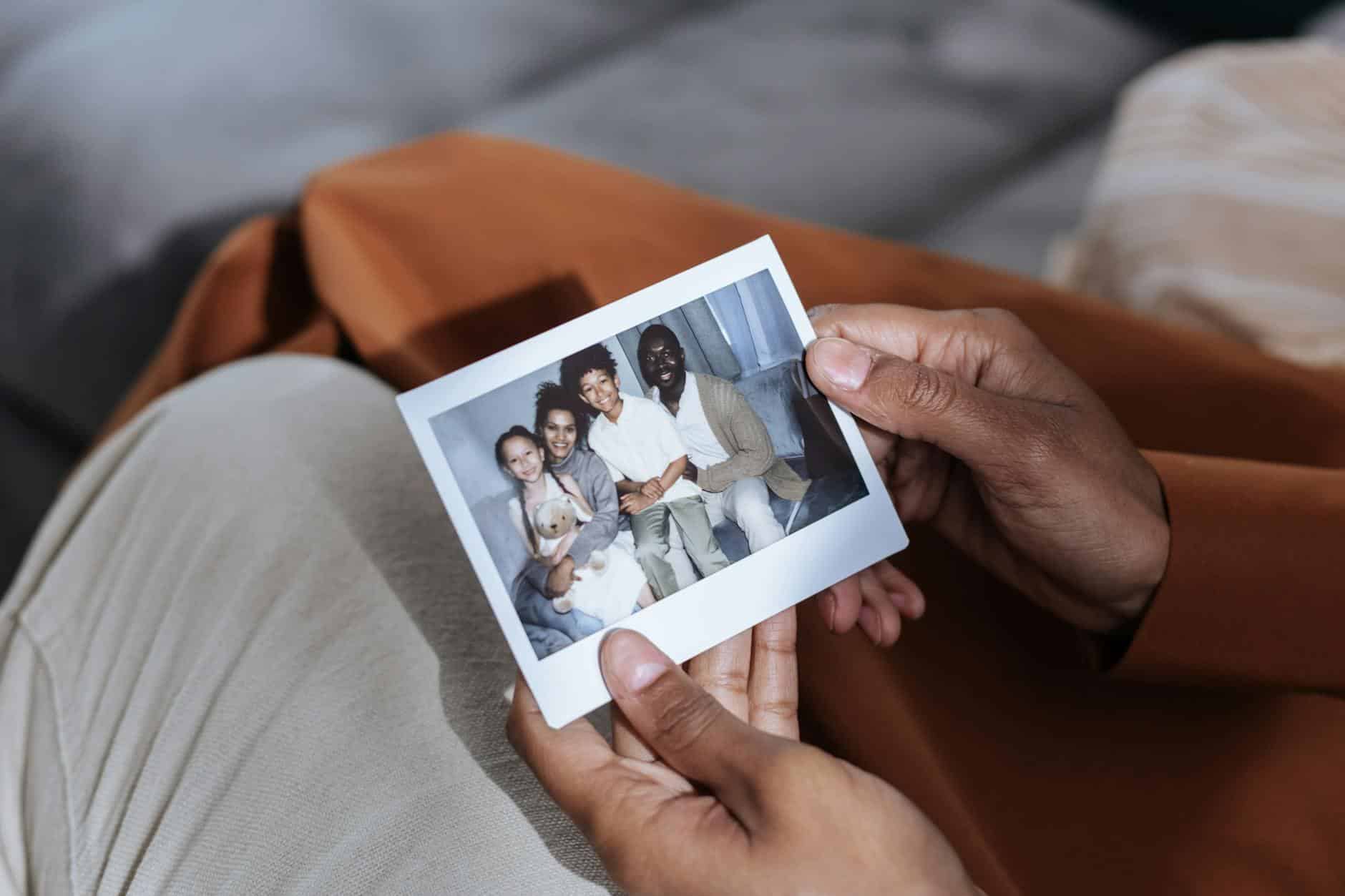 A close-up of hands holding a family photograph, emphasizing memories and connection.