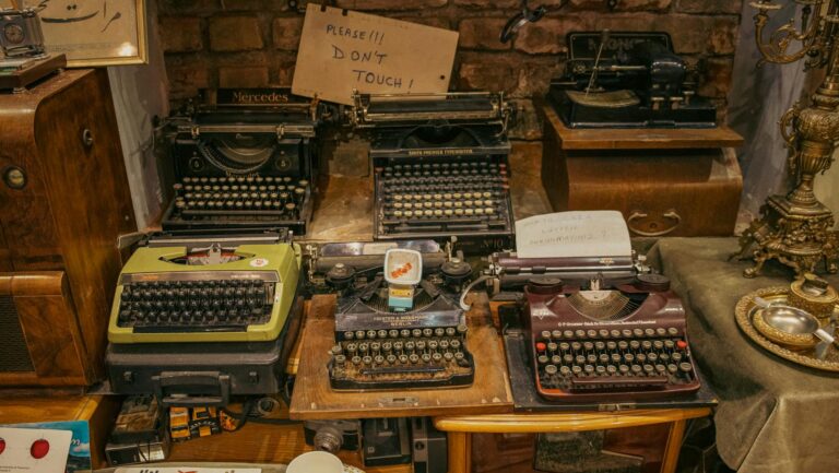 A collection of vintage typewriters displayed in an antique shop, creating a nostalgic retro ambiance