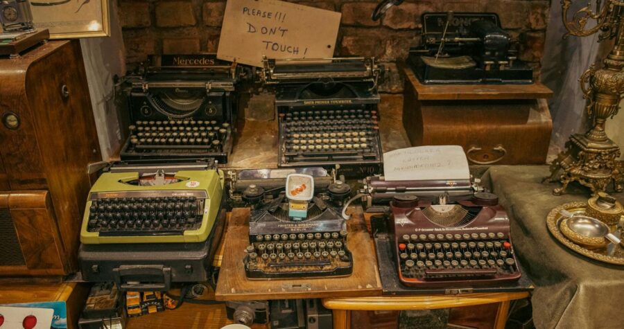 A collection of vintage typewriters displayed in an antique shop, creating a nostalgic retro ambiance