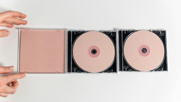 A minimalistic flat lay of CDs designed to resemble abstract feminist art using optical discs