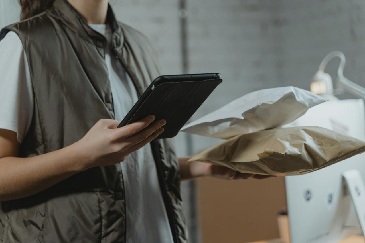 A person using a tablet to manage packages in an indoor setting, highlighting technology and logistics