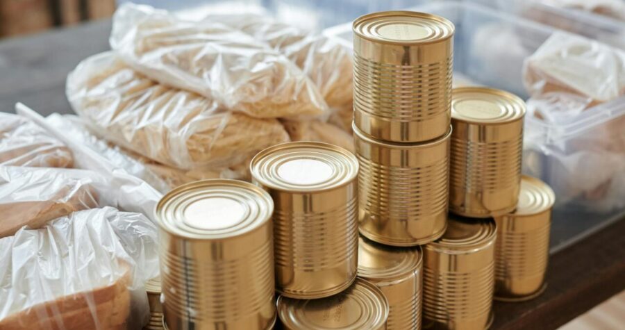 A stack of canned goods and packaged foods on a table, perfect for donation drives.
