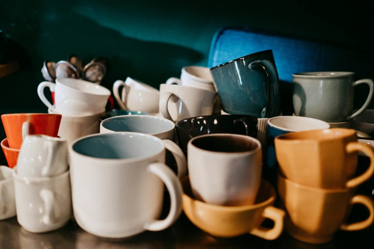 A vibrant collection of various ceramic coffee mugs displayed in a cozy setup.