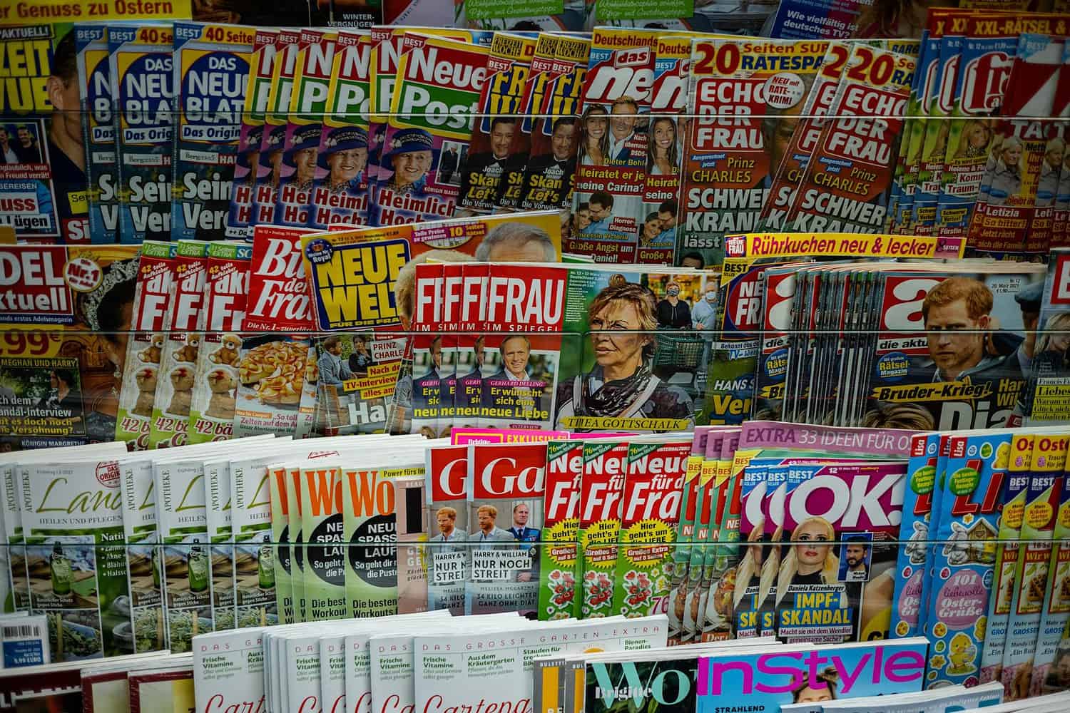 A vibrant display of magazines in a newsstand, showcasing various colorful covers and headlines