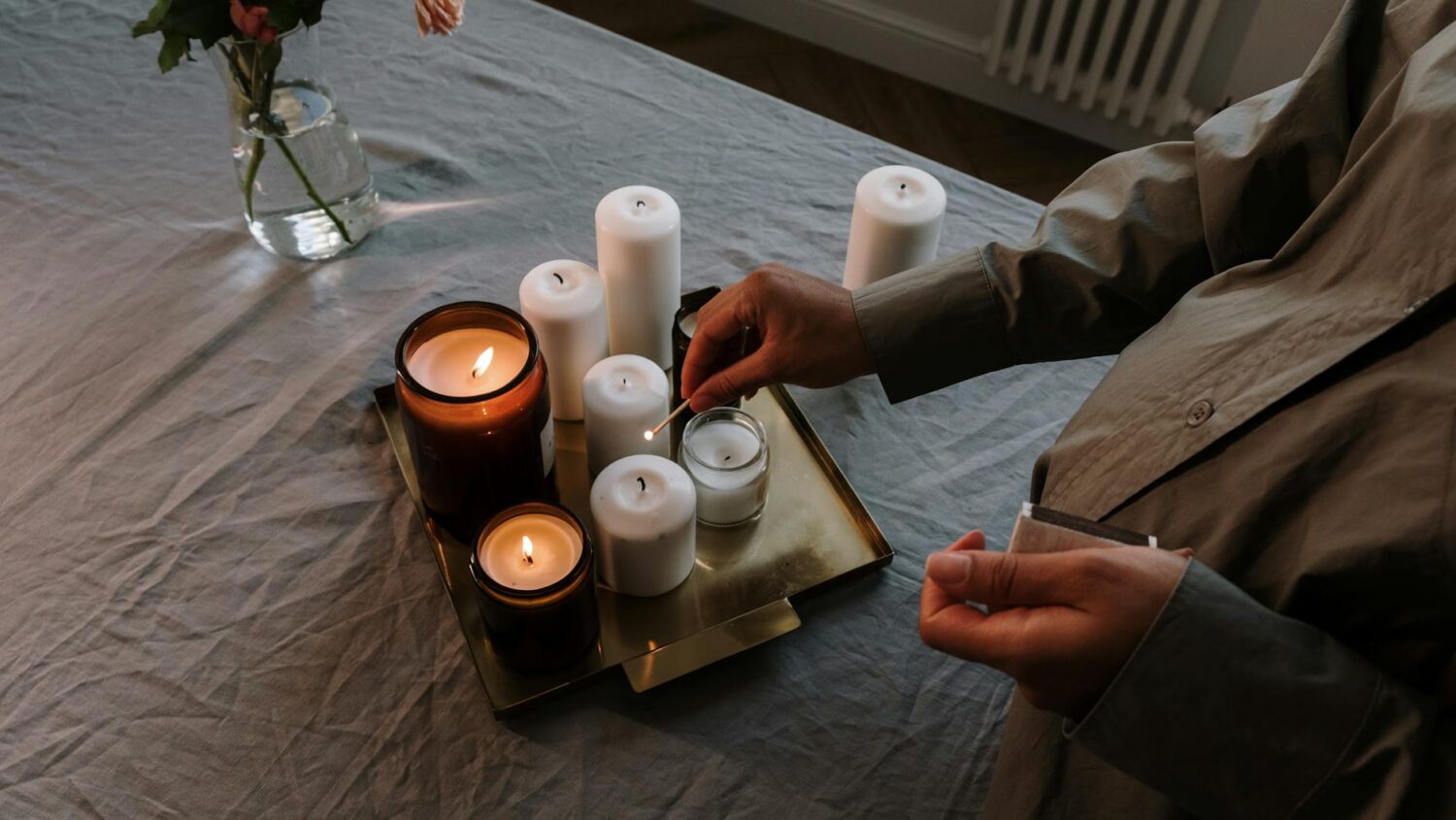 A warm and inviting indoor scene with lit candles and flowers on a table, perfect for relaxation.