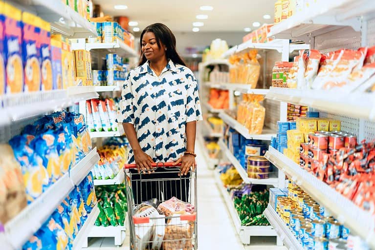 A woman enjoying grocery shopping in a vibrant Lagos supermarket aisle
