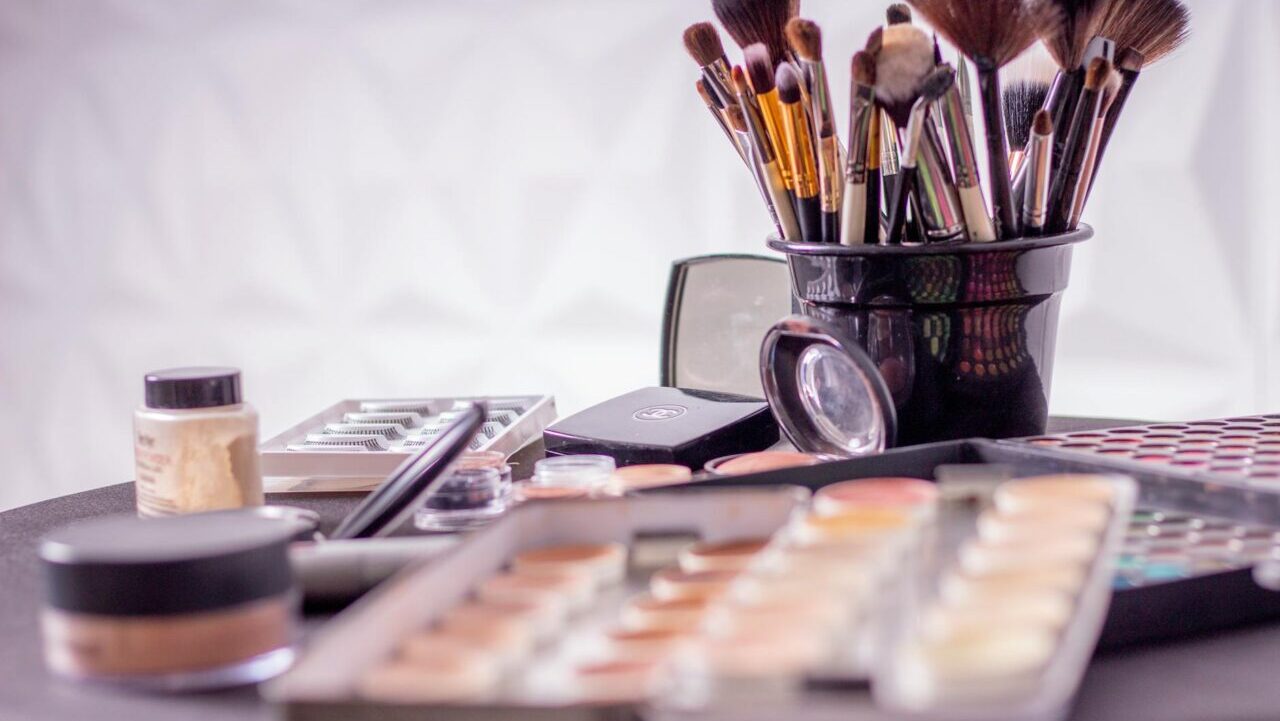 Close-up of a professional makeup brush set and cosmetics on a table for beauty use