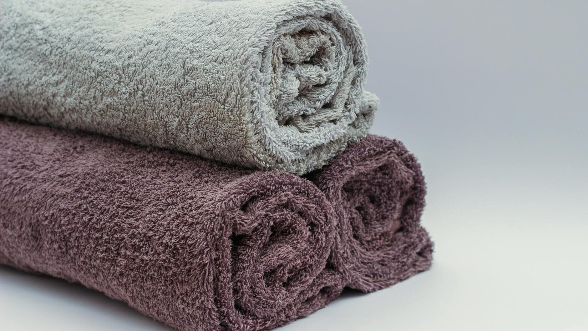 Close-up of rolled bathroom towels in neutral tones, ideal for interior design or spa themes