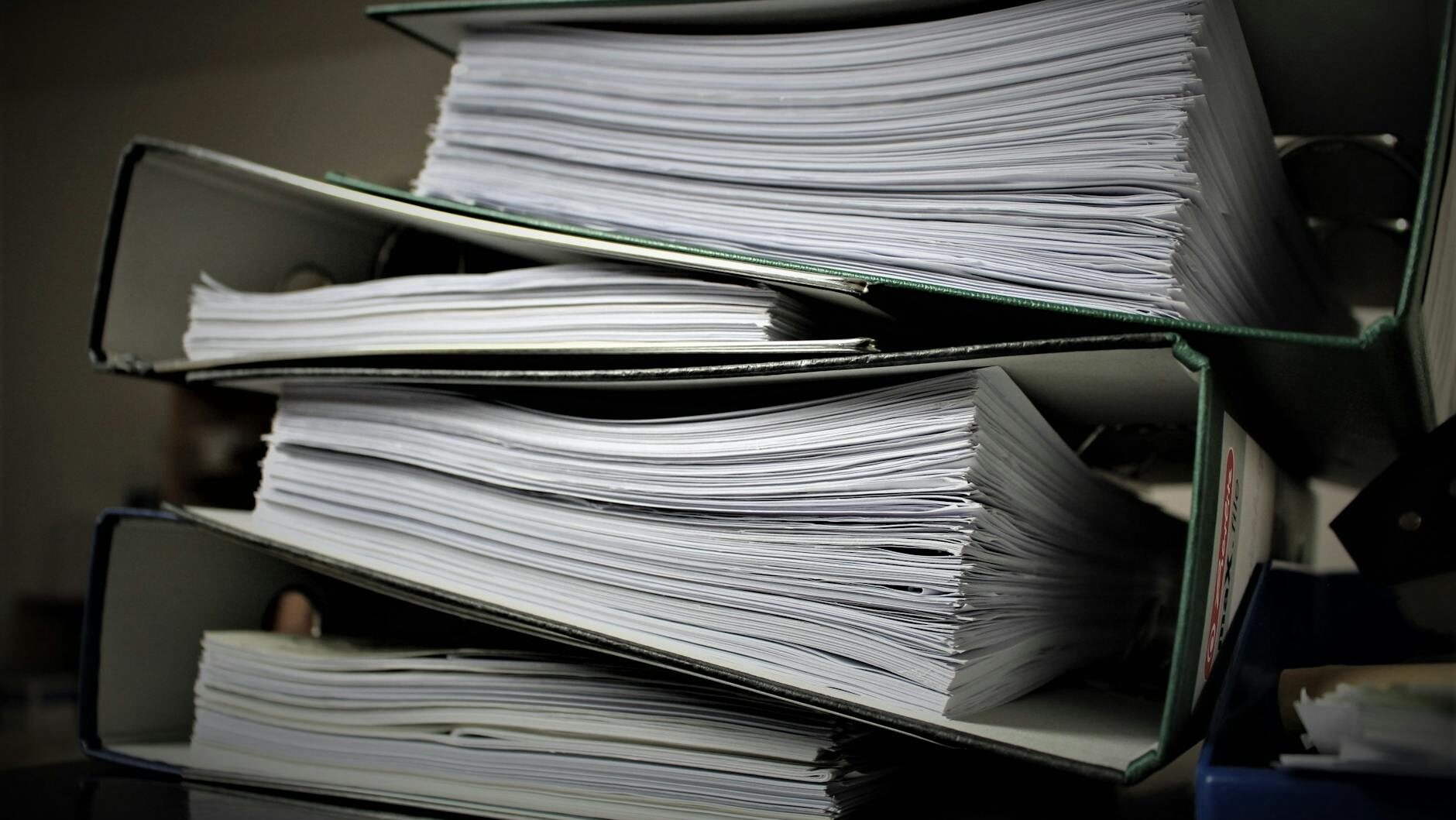 Close-up of stacked binders filled with documents for office or educational use.