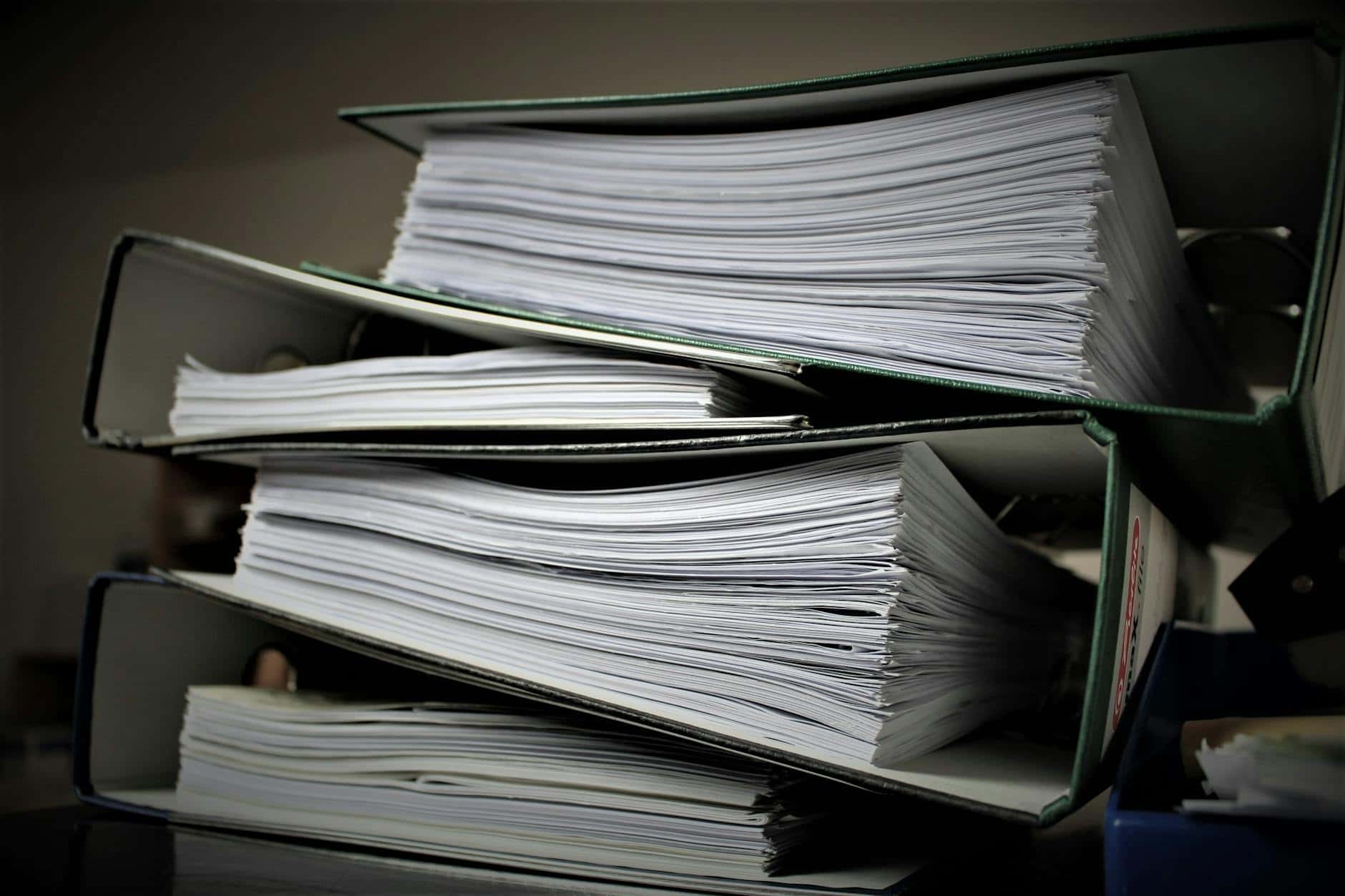 Close-up of stacked binders filled with documents for office or educational use.