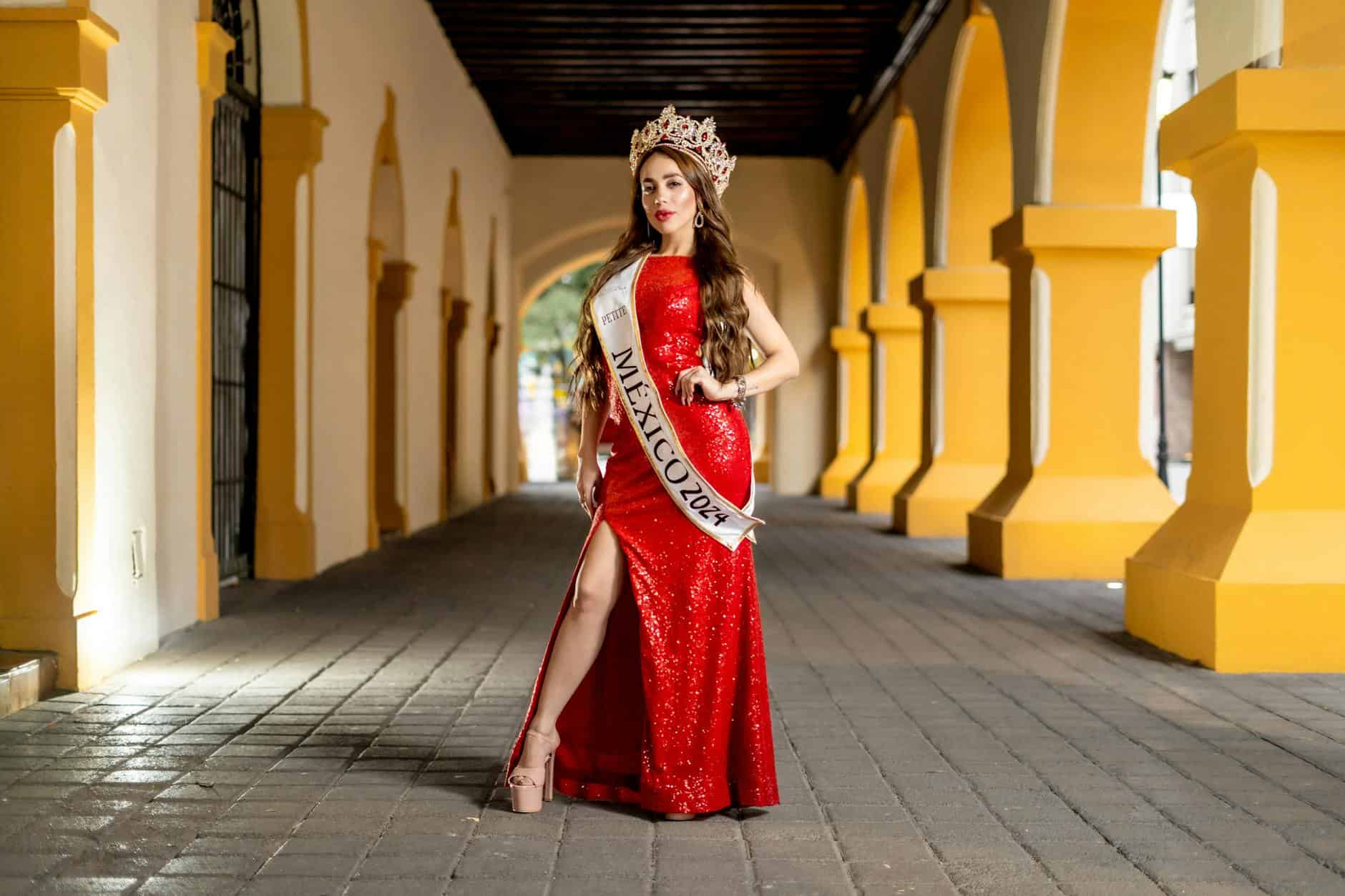 Miss Mexico 2024 contestant in a red gown, standing in a historic Monterrey archway.