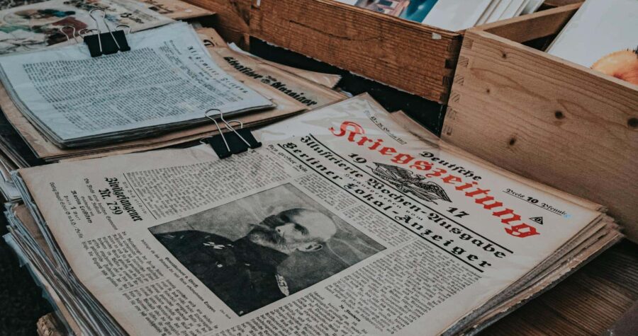 Retro German newspapers featuring historical portraits in wooden boxes, evoking a vintage aesthetic.