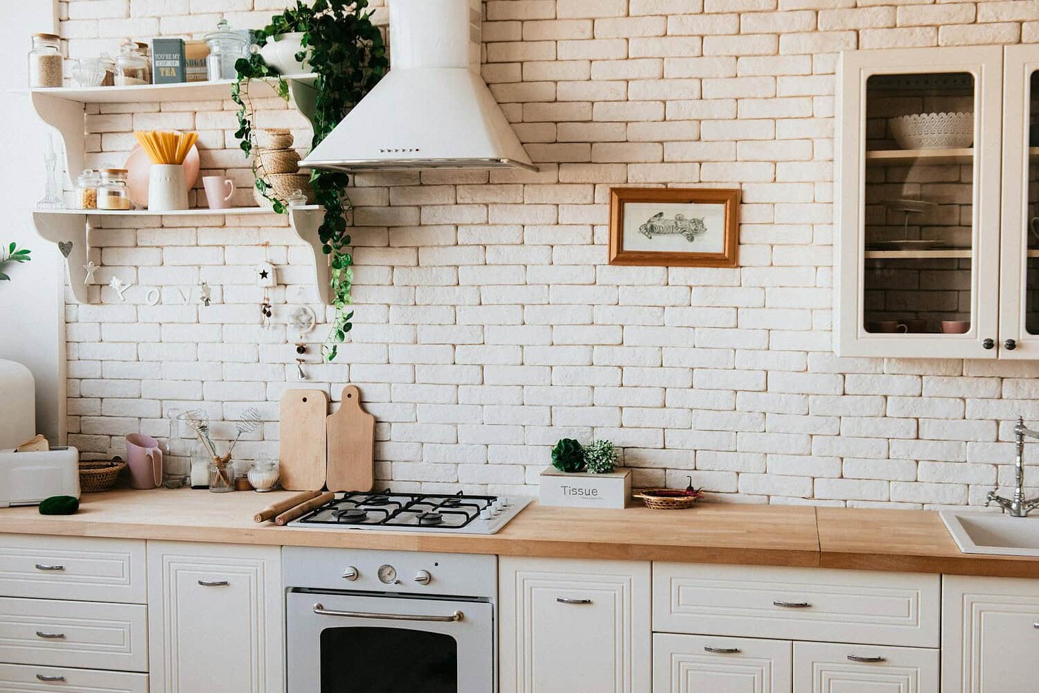 Stylish kitchen interior with modern appliances, wooden counters, and greenery accents.