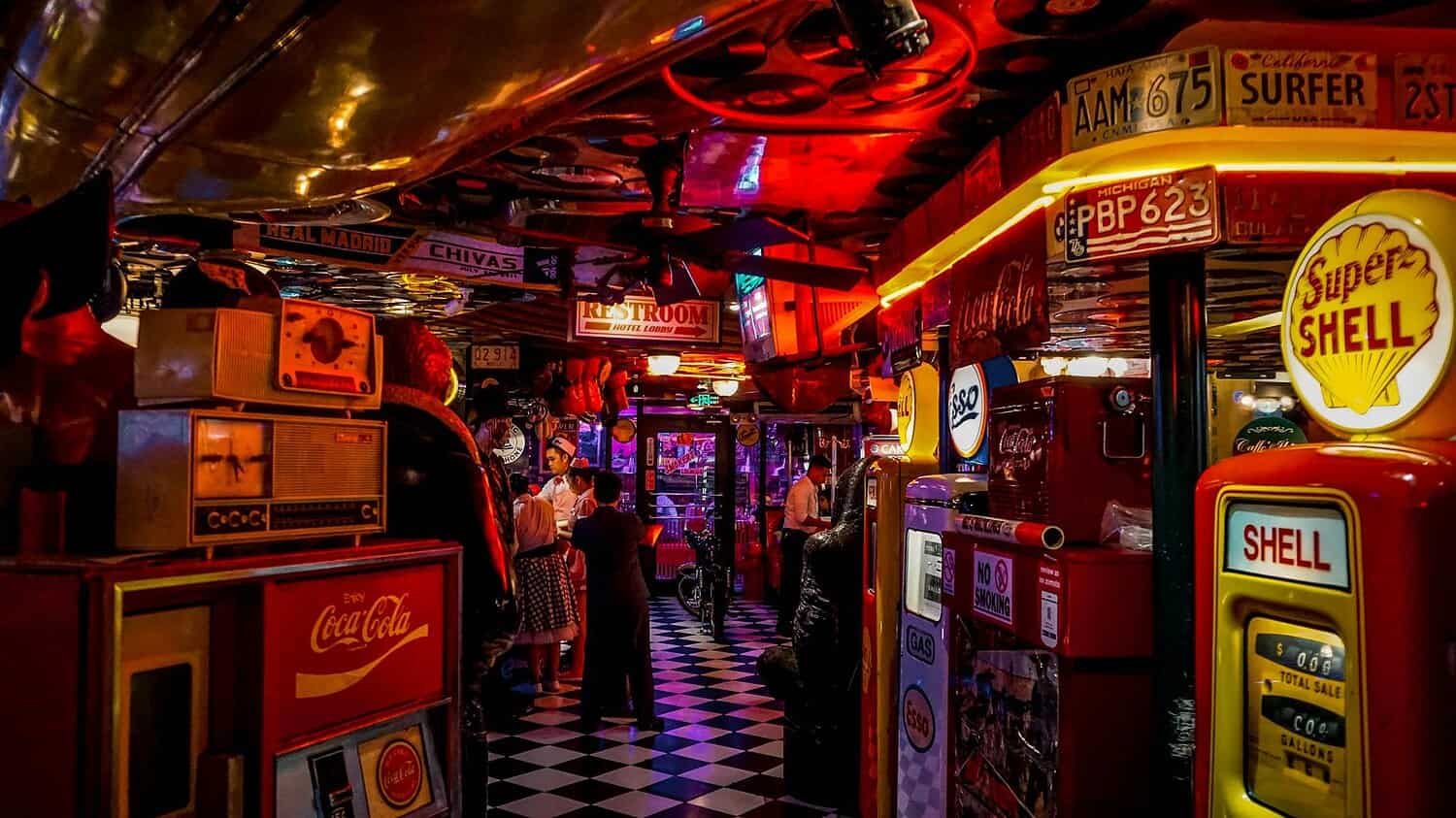 Vintage arcade bar with retro signs, people, and neon lights