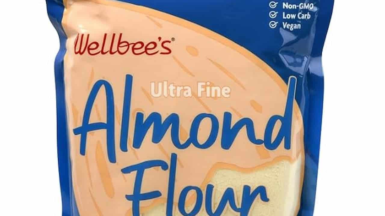 A blue and tan package labeled "Wellbee’s Ultra Fine Almond Flour" with non-GMO, low carb, and vegan icons
