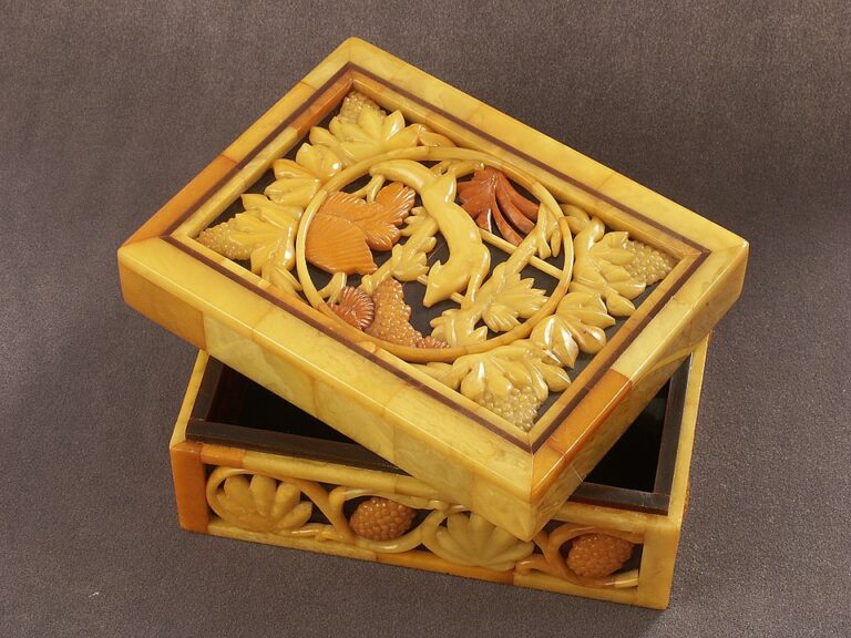 Wooden decorative box, partially open lid, intricate floral and bird design on top, rich yellow and brown tones, placed on a brown surface