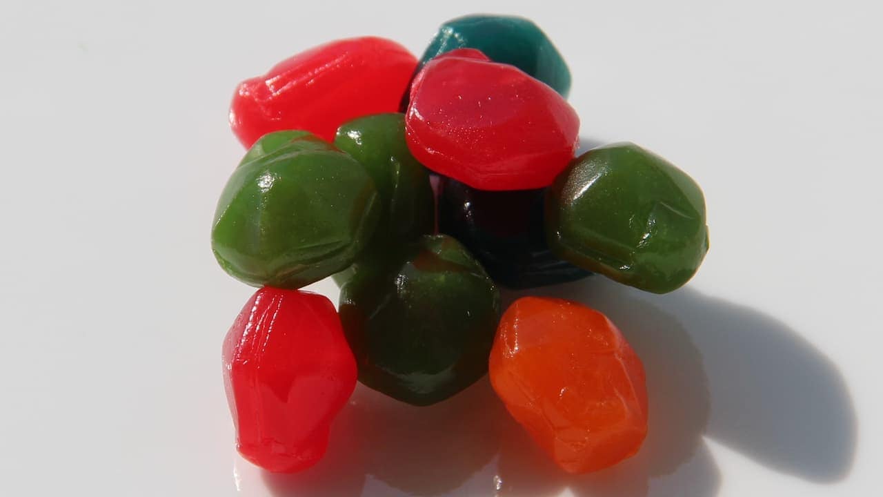 Colorful Gushers in red, green, dark blue, and orange clustered together on a white surface with cast shadows