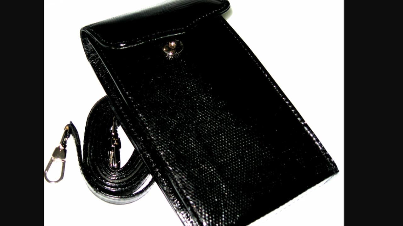 A glossy black leather pouch with a snap-button flap and an attached shoulder strap, featuring metal clasps at both ends of the strap, displayed on a white background