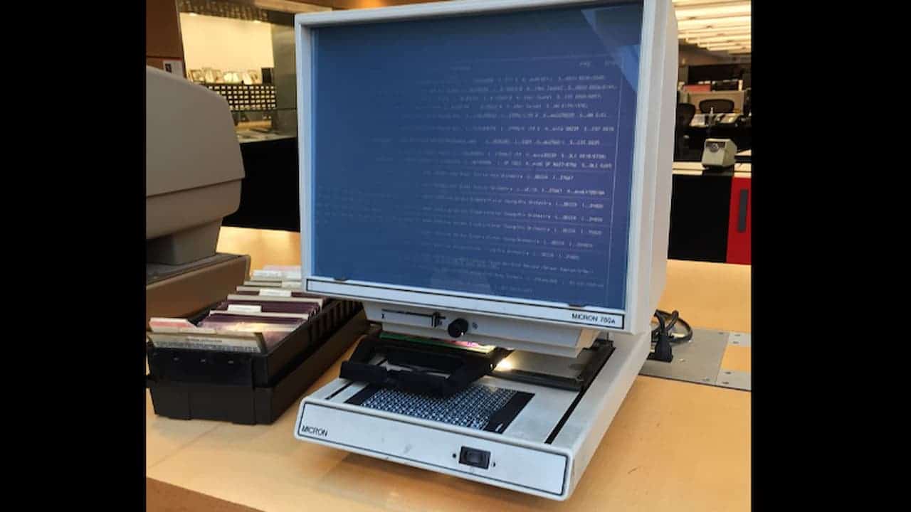 Historical document research in a library, archival data retrieval, viewing old newspaper records, or studying government records stored on microfilm