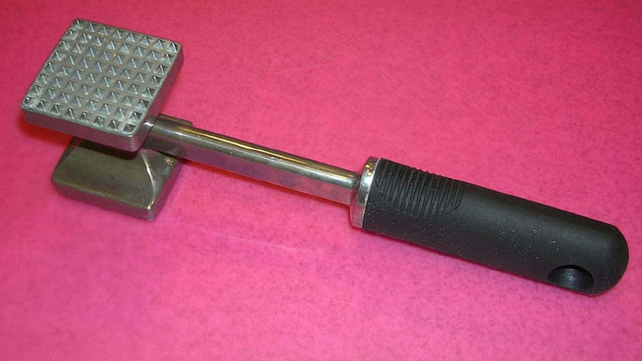 A metal meat tenderizer with a dual-sided head—one flat and one textured—attached to a metal shaft and black rubberized handle